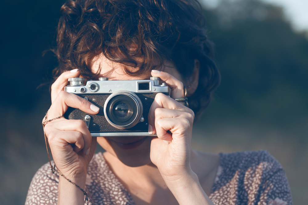 portrait of a beautiful smiling girl with retro camera. Happy lifestyle
