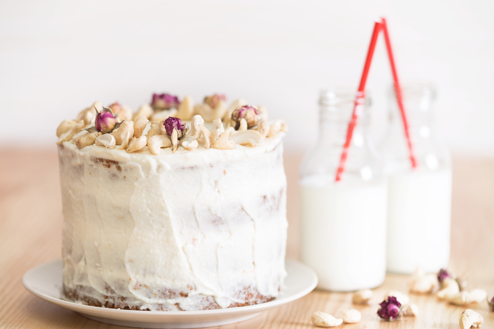 beautiful carrot cake decorated with pecans and dry roses. next to the milk bottle. still life