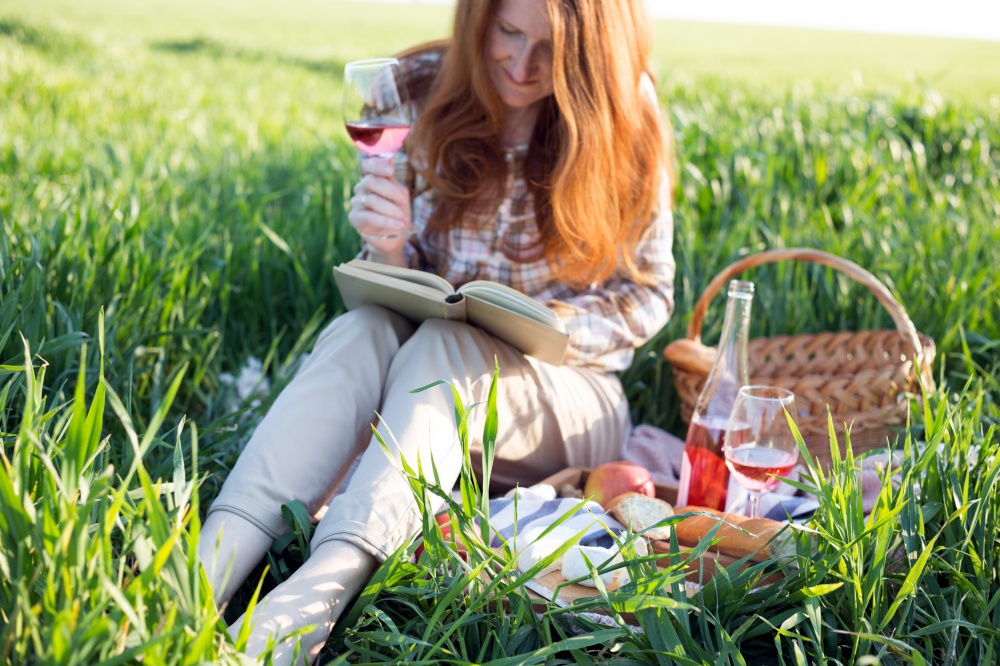 Summer - Provencal picnic in the meadow.  girl with a glass of wine and book near a picnic basket and baguette