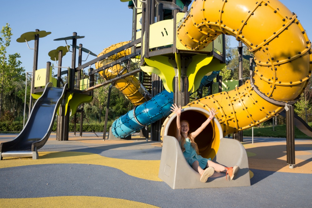girl at the  large beautiful playground in the park.  Summer and active lifestyle