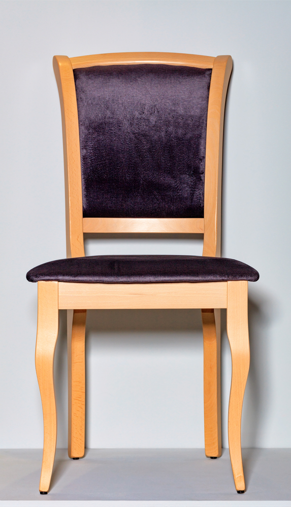 Classic wooden chair with soft dark purple upholstery, photographed frontally, on a gray podium and background.. Wooden chair with a soft saddle on a gray podium and background.