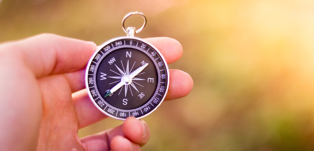 Vintage compass in man&rsquo;s hand, adventure and discovery concept