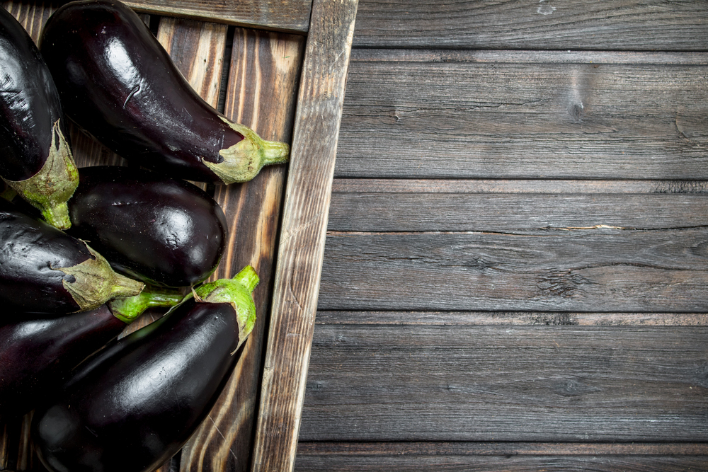 Eggplant on a wooden tray. On wooden background. Eggplant on a wooden tray.