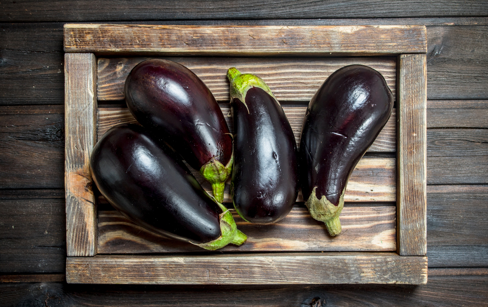 Eggplant on a wooden tray. On wooden background. Eggplant on a wooden tray.