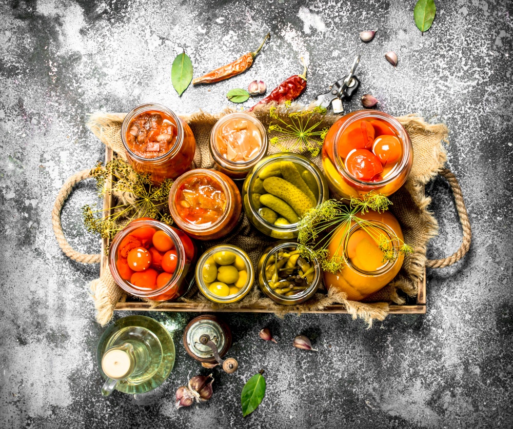 Preserved vegetables with mushrooms on an old tray. On a rustic background.. Preserved vegetables with mushrooms on an old tray.