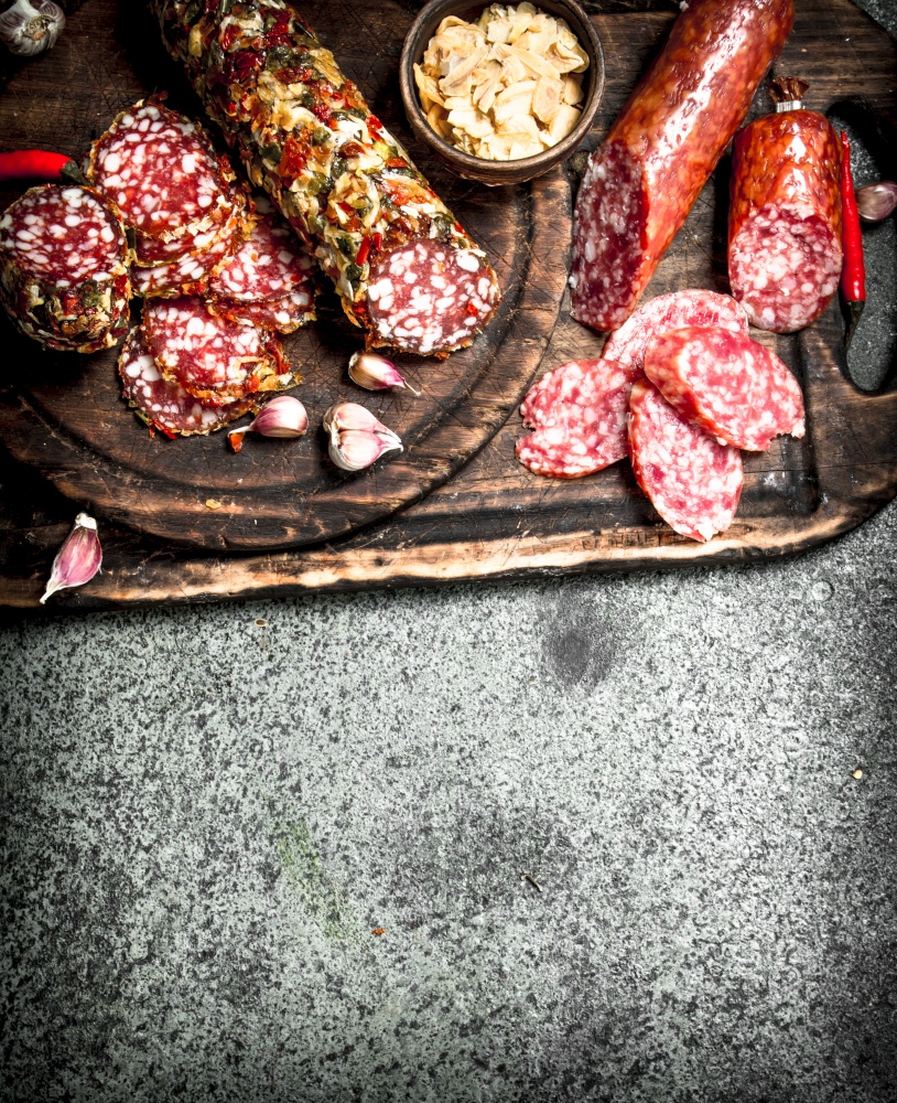 variety of salami with spices and herbs. On a rustic background.. variety of salami with spices and herbs.