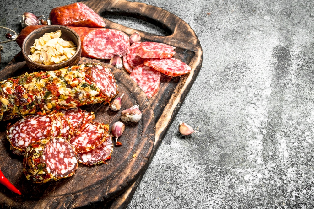 variety of salami with spices and herbs. On a rustic background.. variety of salami with spices and herbs.