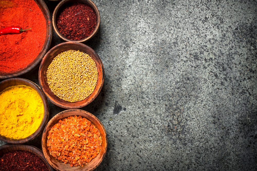 Ground spices in bowls. On a rustic background.. Ground spices in bowls.