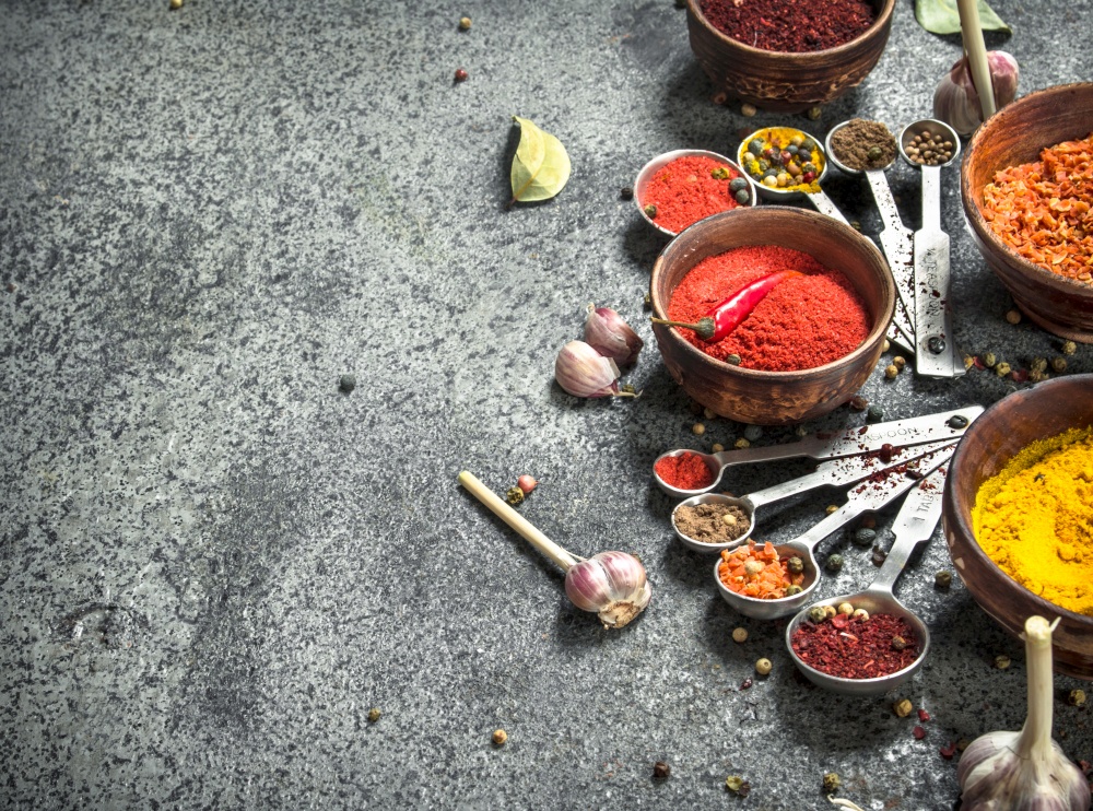 Various herbs and spices with measuring spoons. On a rustic background.. Various herbs and spices with measuring spoons.