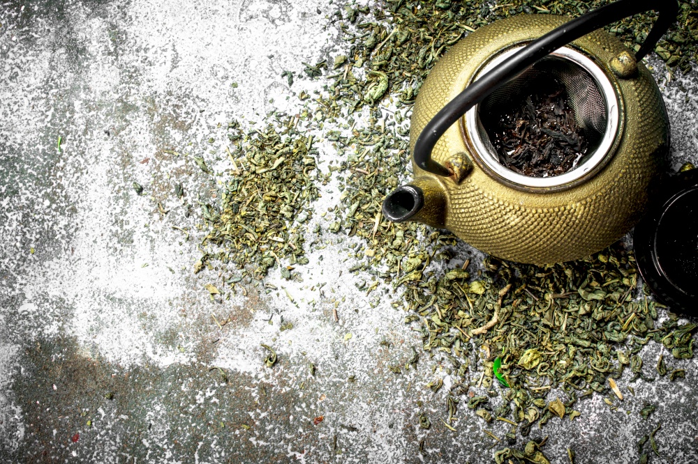 Green tea with a teapot. On a rustic background.. Green tea with a teapot.