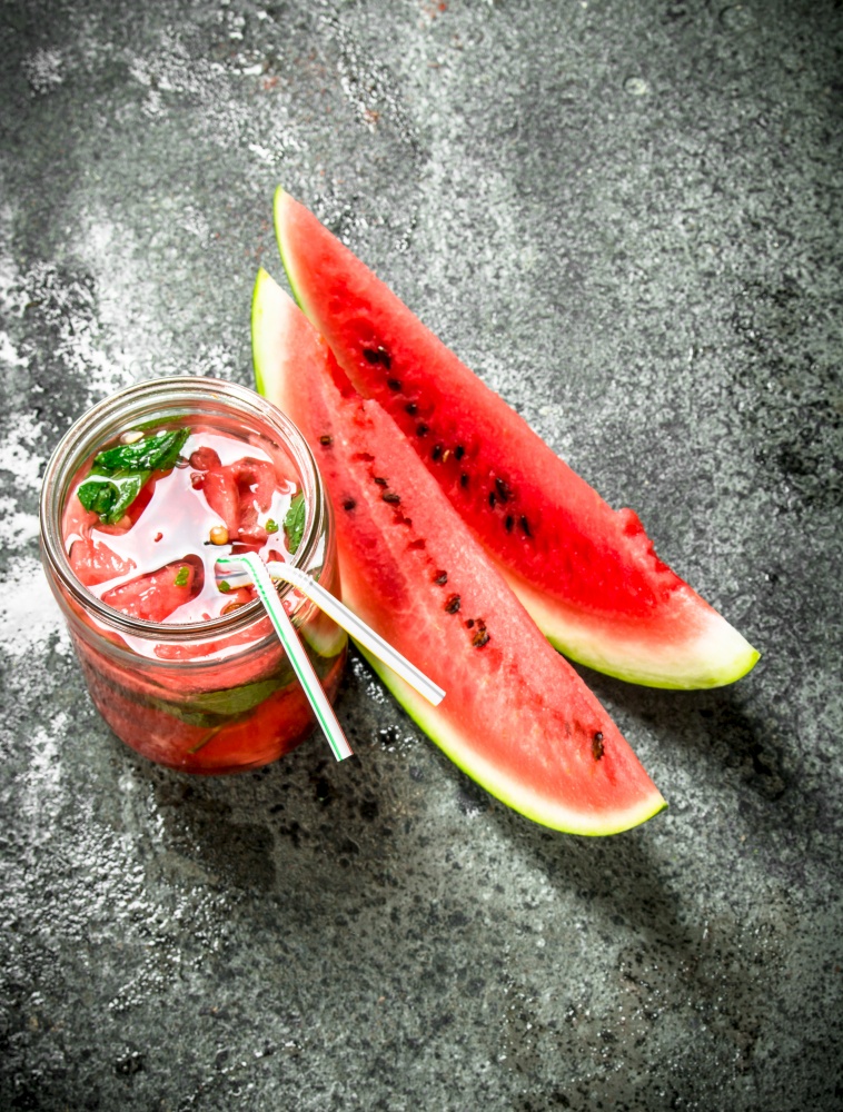 Watermelon juice with mint in glass jar. On a rustic background.. Watermelon juice with mint in glass jar.