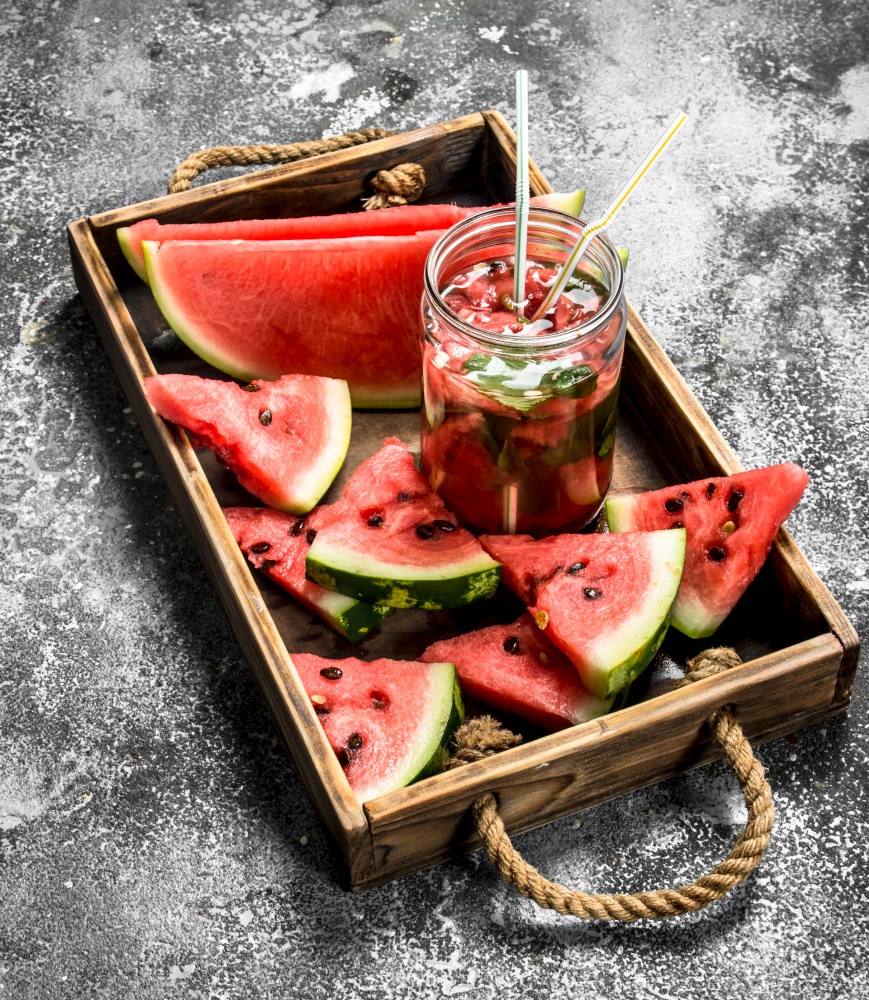 Watermelon cocktail on a wooden tray. On a rustic background.. Watermelon cocktail on a wooden tray.