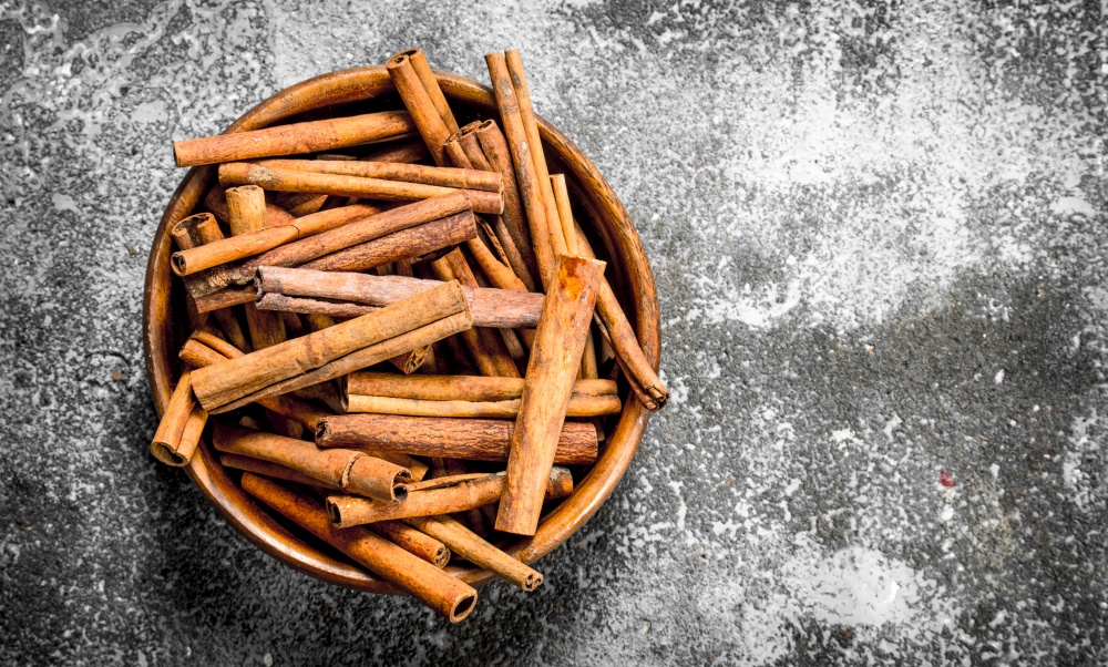 Sticks of cinnamon in a bowl. On rustic background .. Sticks of cinnamon in a bowl.