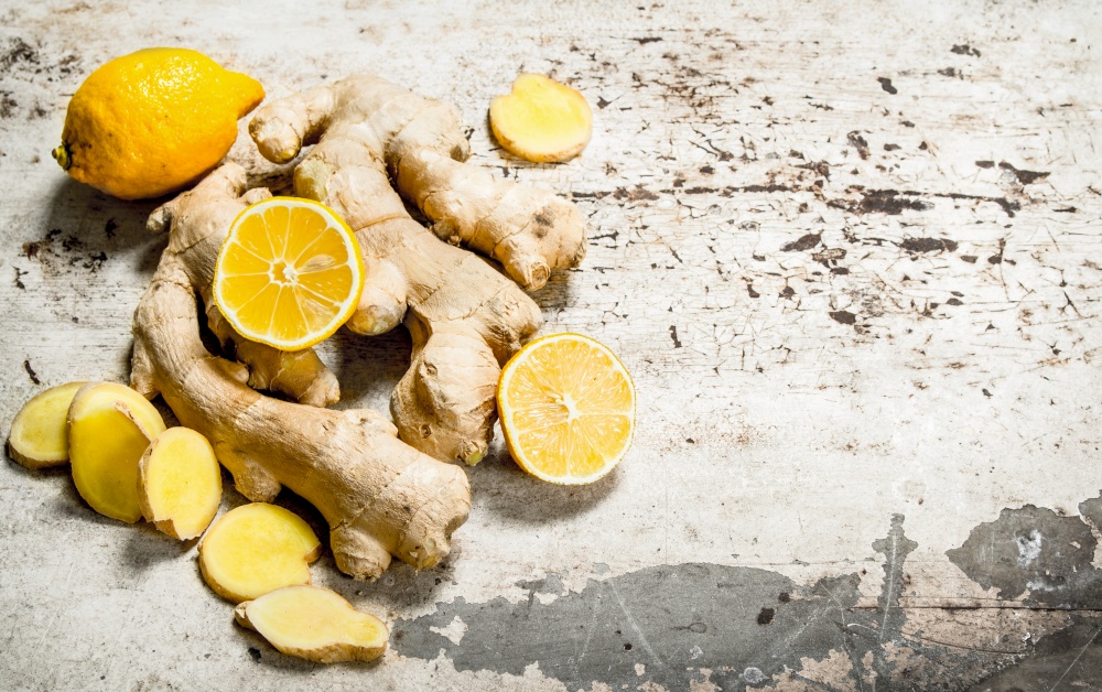 Fresh ginger with lemons. On rustic background.. Fresh ginger with lemons.