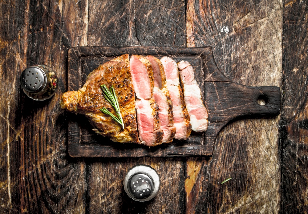 Grilled beef steak with spices. On wooden background.. Grilled beef steak with spices.