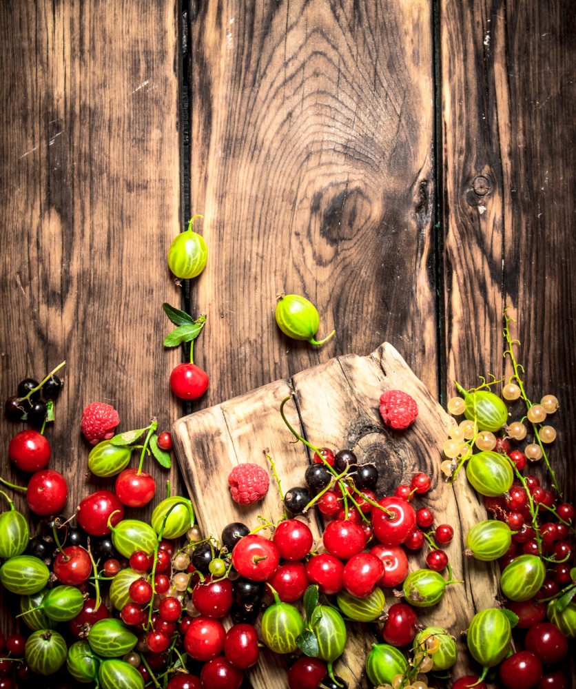 Forest berries on the Board. On a wooden background.. Forest berries on the Board.