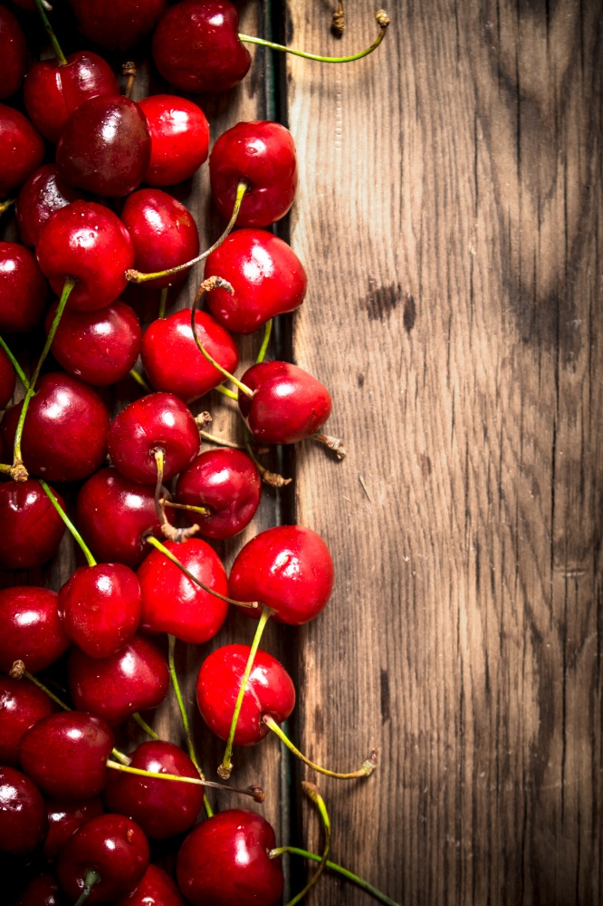 Fresh red cherry . On a wooden background.. Fresh red cherry