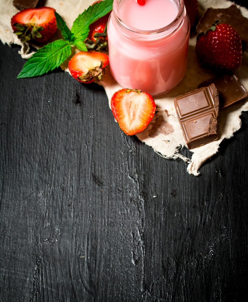 Strawberry smoothie with chocolate and mint. On a black wooden background.. Strawberry smoothie with chocolate and mint.