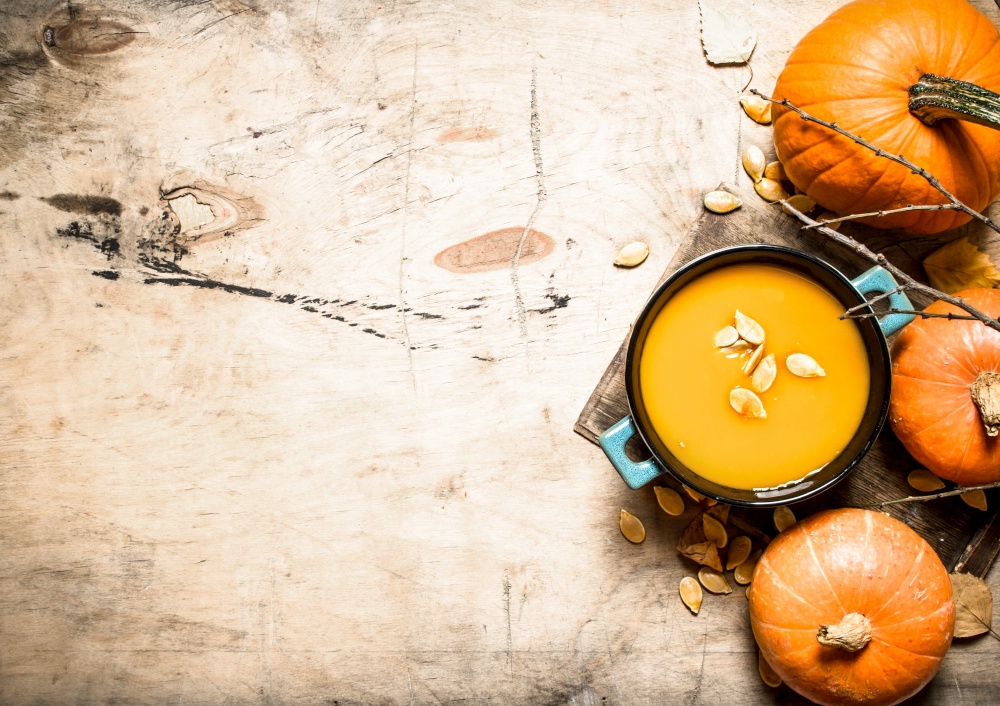 Pumpkin soup. Cooked soup from a ripe pumpkin. On wooden background.. Cooked soup from a ripe pumpkin.