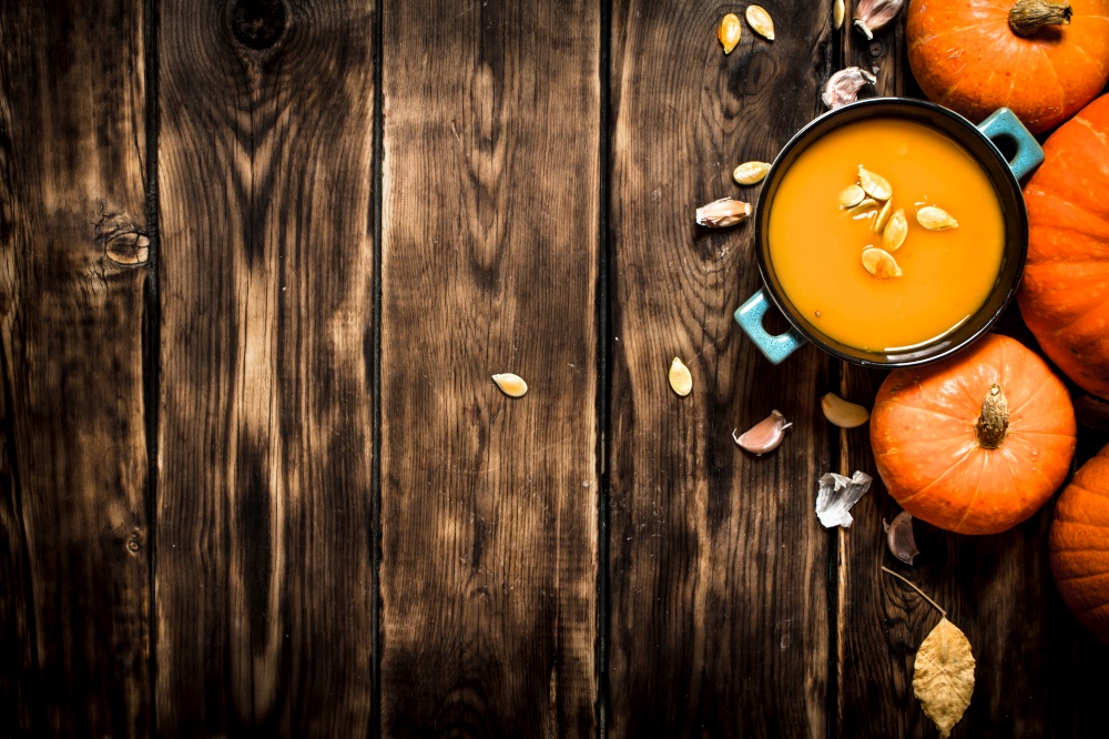 Autumn style. Fresh pumpkin soup. On wooden background. Fresh pumpkin soup.