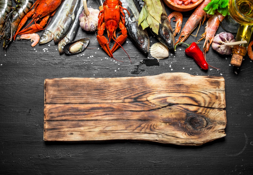 Fresh seafood. Cutting Board with a variety of shrimp, fish and shellfish. On a black chalkboard.. Cutting Board with a variety of shrimp, fish and shellfish.