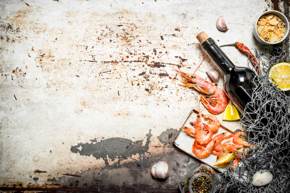 Fresh seafood. Wine with shrimp and spices with a fishing net. On rustic background .. Wine with shrimp and spices