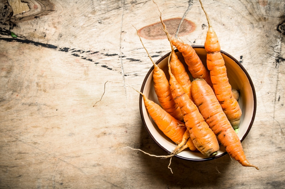 Healthy food. Organic carrots in a bowl . On wooden background.. Healthy food. Organic carrots in a bowl .