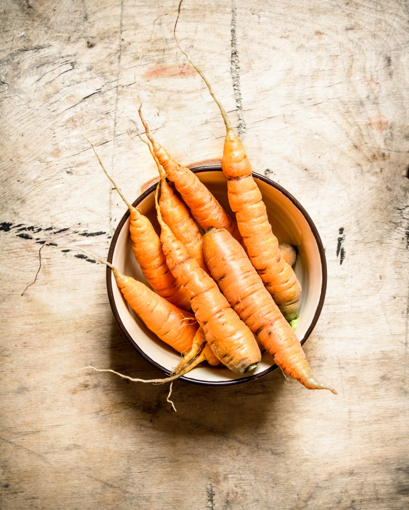 Healthy food. Organic carrots in a bowl . On wooden background.. Healthy food. Organic carrots in a bowl .