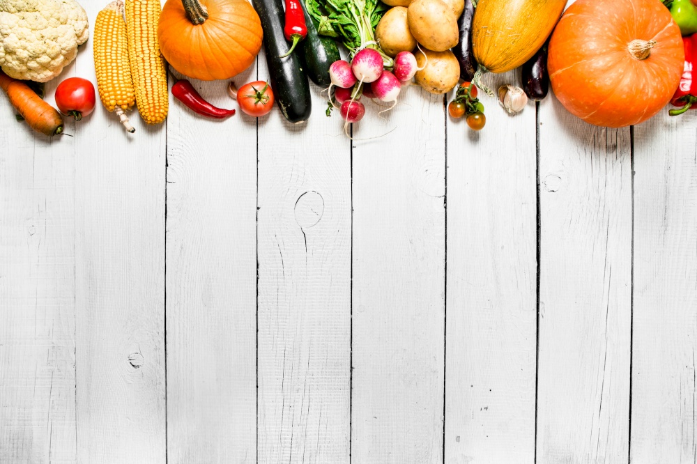 Organic vegetables. Different raw vegetables . On a white wooden background.. Different raw vegetables .