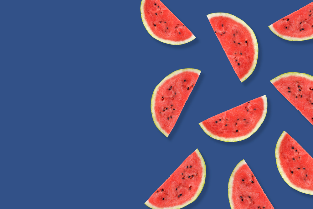Flat lay of watermelon half slices on blue background. Watermelon pattern. Creative Minimal summer pop art concept. Copy space. Trendy banner toned in classic blue - color of the 2020 year.. Flat lay of watermelon half slices on blue background. Watermelon pattern.