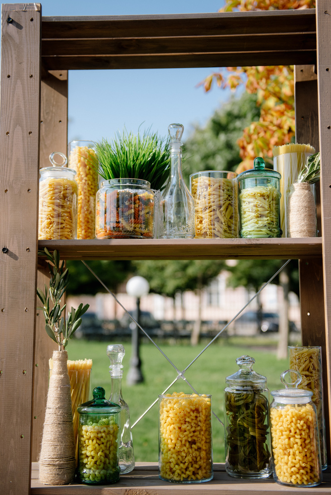 Variety of types and shapes of Italian pasta in glass jars. avarious types of pasta, fusilli and farfalle, in glass jars