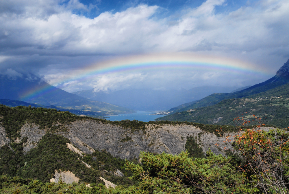 a mountain landscape with a beautiful rainbow