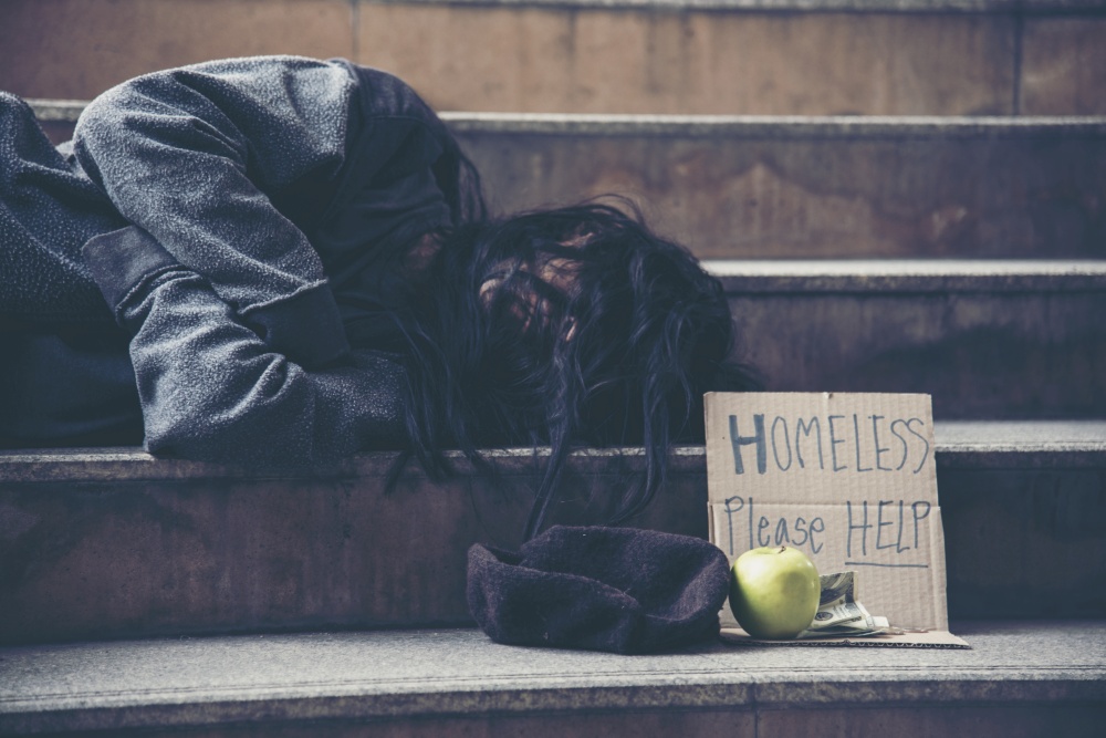Homeless people poverty beggar man asking for money job and hoping help in helpless dirty city sitting with sign of cardboard box said