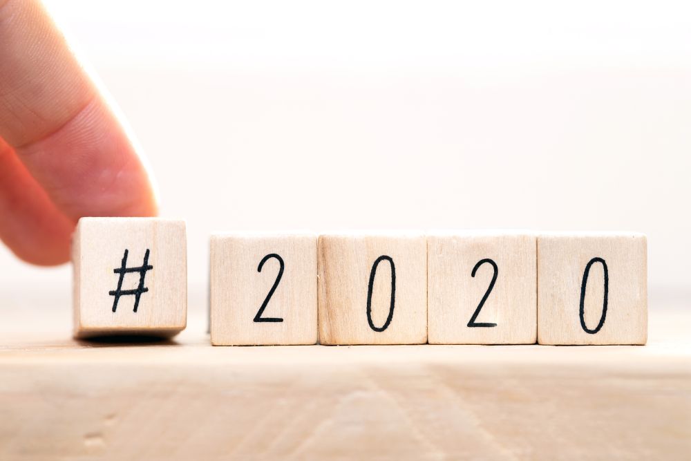 Hashtag 2020 concept, hand change wooden cubes close-up with white background close-up. Hashtag 2020 concept, hand change wooden cubes close-up with white background