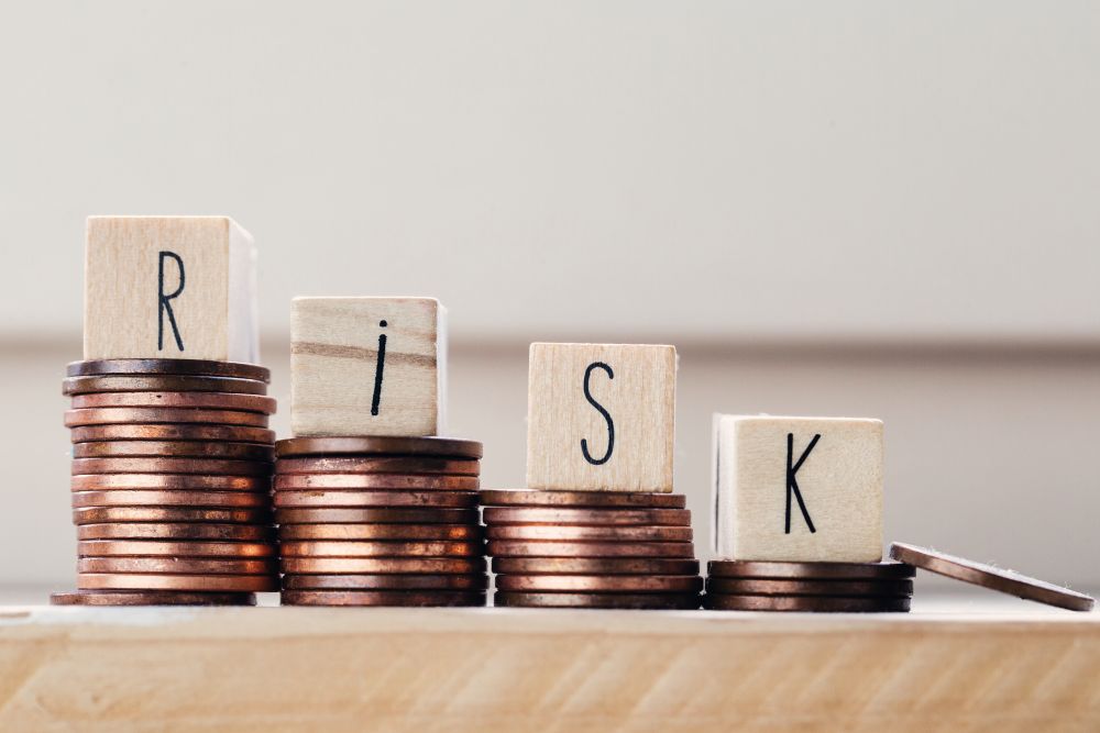 Wooden cubes with the word Risk and pile of coins, money climbing stairs. Business concept background. Wooden cubes with the word Risk and pile of coins, money climbing stairs. Business concept
