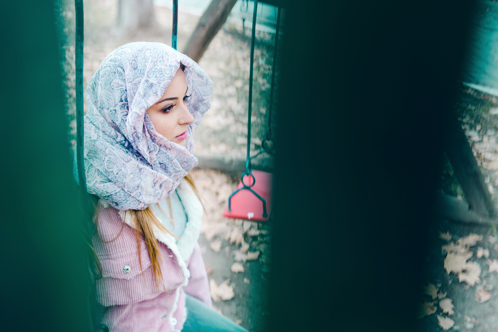 Young Woman On The Swing In Park side view scarf hijab