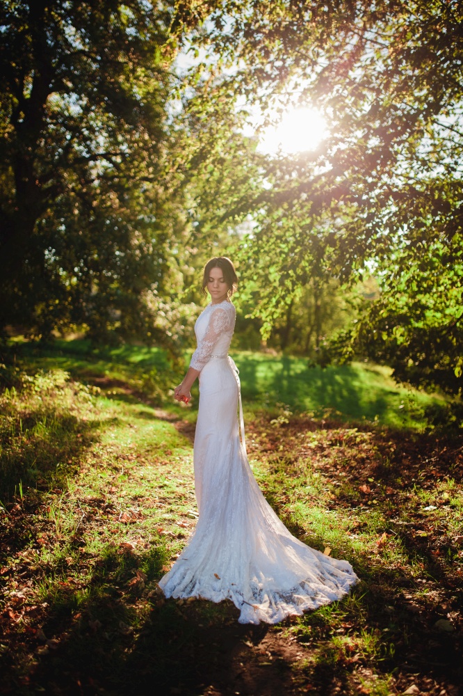 bride in wedding dress standing in woods.. bride in wedding dress standing in woods