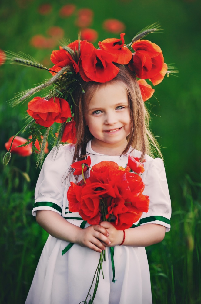beautiful little girl with a wreath of poppies in a white dress and a bouquet of wildflowers. cute child in poppy field.. beautiful little girl with a wreath of poppies in a white dress and a bouquet of wildflowers. cute child in poppy field
