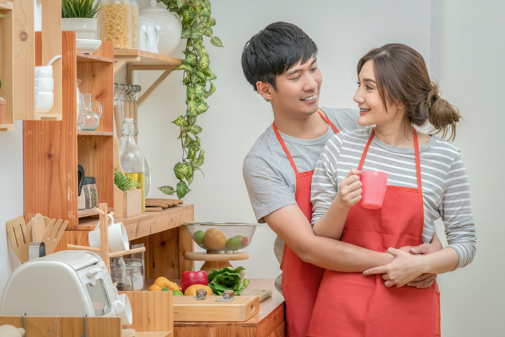 Asian Lover or Couple cooking and Tasting food in the kitchen room at the modern house, Couple and life style concept.