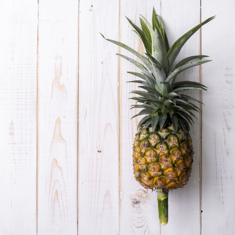 Pineapple on white wooden background