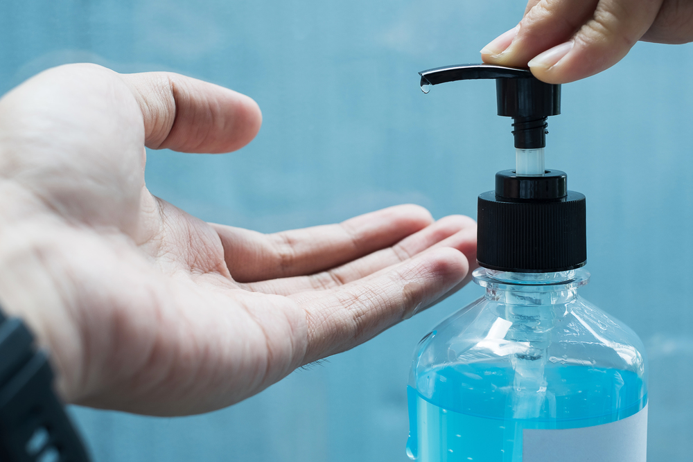 man hands using wash hand sanitizer gel dispenser, against Novel coronavirus or Corona Virus Disease (Covid-19) at public train station. Antiseptic, Hygiene and Healthcare concept