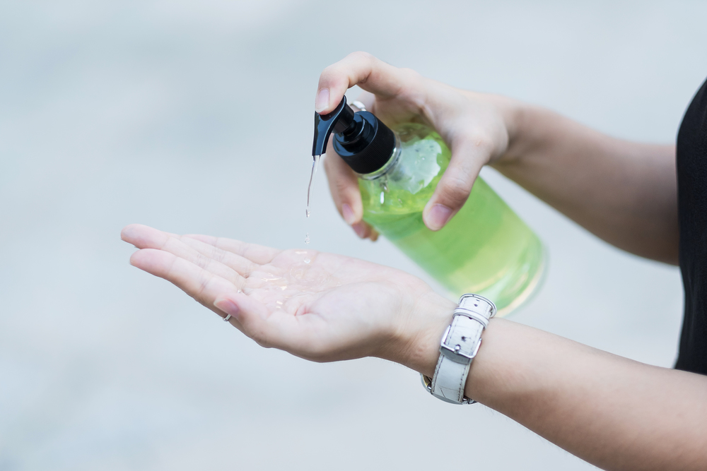 Woman hands using wash hand sanitizer gel dispenser, against Novel coronavirus or Corona Virus Disease (Covid-19) at public Indoor. Antiseptic, Hygiene and Healthcare concept