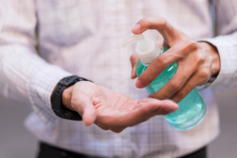 man hand using wash hand sanitizer gel dispenser, against Novel coronavirus or Corona Virus Disease (Covid-19) at public Indoor. Antiseptic, Hygiene and Healthcare concept