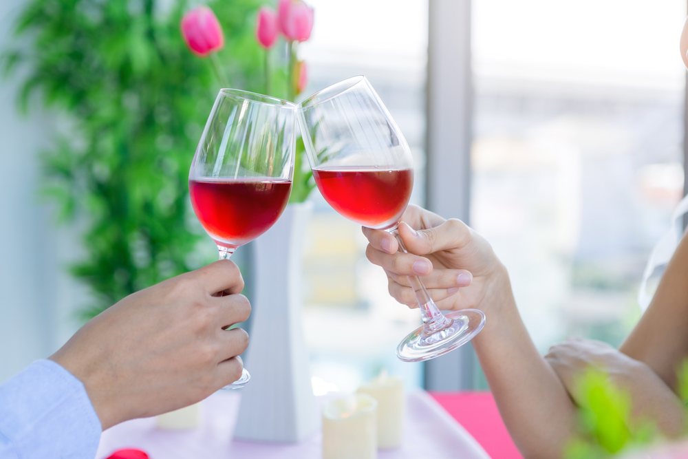 Valentine&rsquo;s day concept,Close-up of couple having romantic the Lunch with clinking toasting wine glasses at the restaurant background.