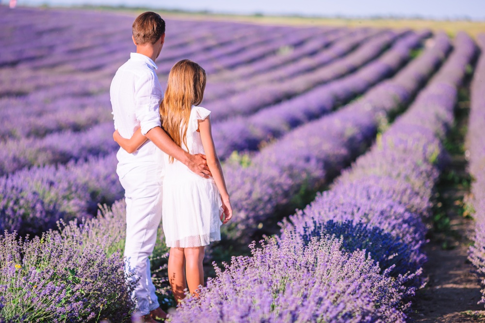 Happy father with cute daughter on purple flower lavender field. Family vacation. Family of two in lavender flowers field