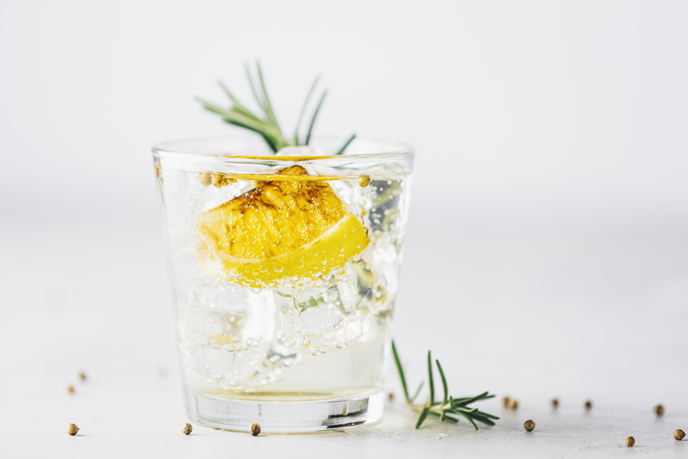 Charred Lemon, Rosemary and Coriander Gin and Tonic is a flavors are perfectly balanced refreshing cocktail. on light background, close up. Summer drinks and alcoholic or detox cocktail