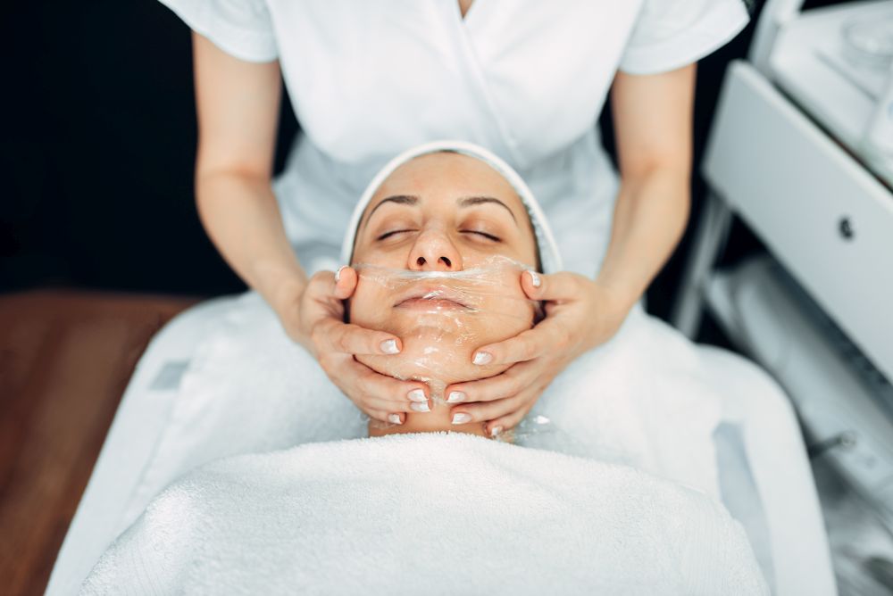 Face massage to female patient, cosmetology clinic. Facial skincare, rejuvenation procedure in spa salon. Face massage to female patient, cosmetology clinic