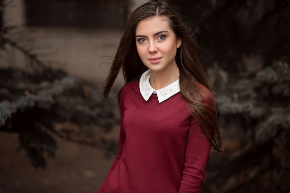 Portrait of young businesswoman in raspberry jacket with white collar outdoor. Portrait of young businesswoman.