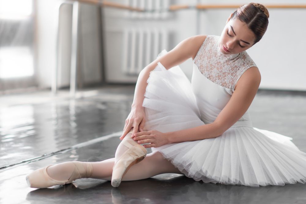 Beautiful ballerina posing in ballet class, barre and white wall on background. Beautiful ballerina posing in ballet class