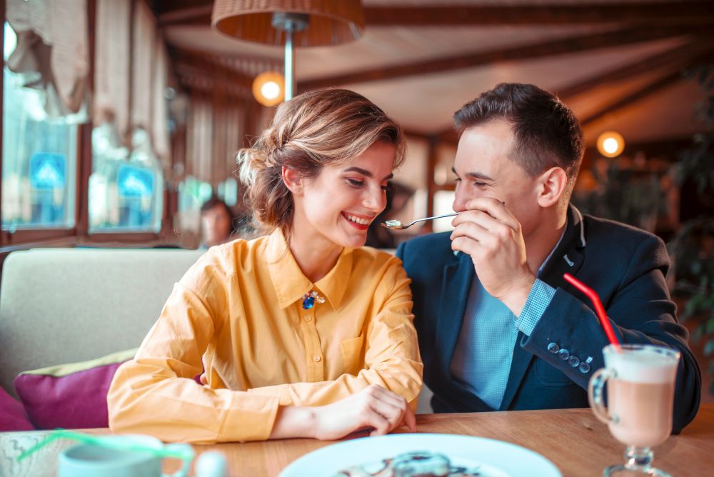 Smiling love couple at romantic date, restaurant on background